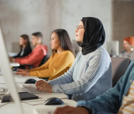 A Woman with a hijab and other diverse people are working in an open office.